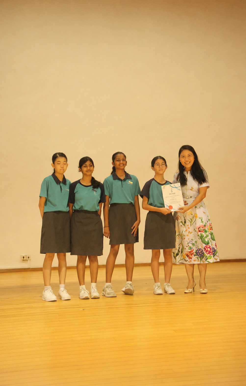 4 girls and 1 adult pose for prize presentation